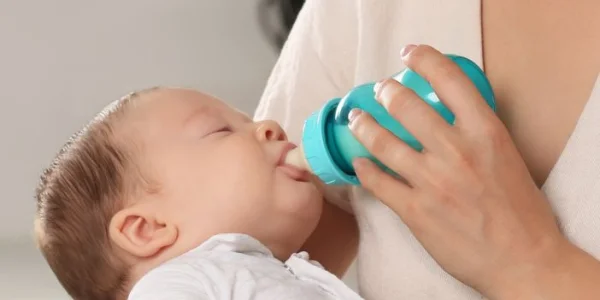 Säugling wird mit Milch aus einer Flasche gefüttert